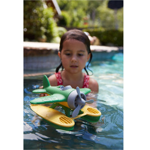 Girl in pool playing with Green Seaplane