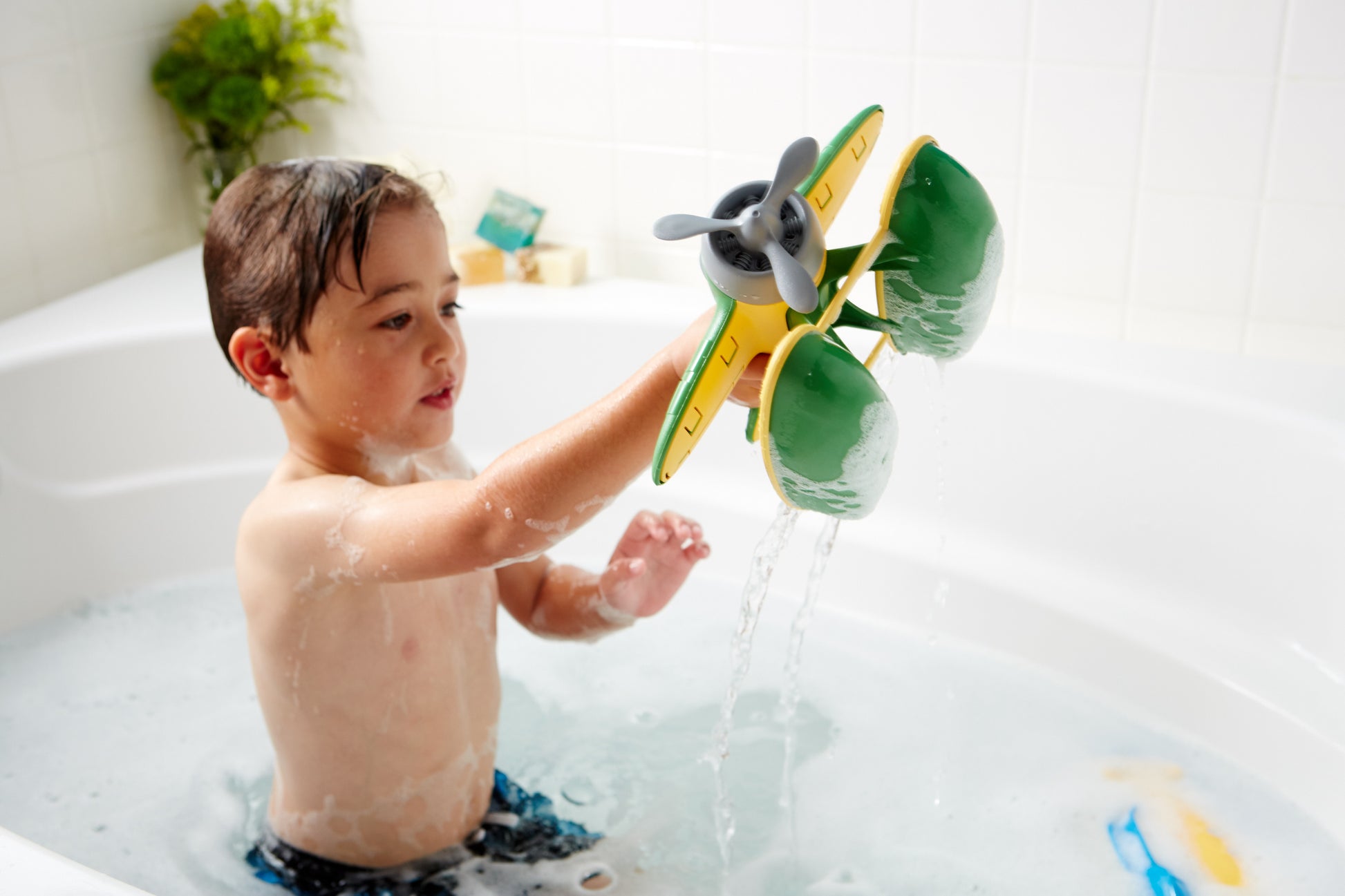 Boy in bath playing with Seaplane