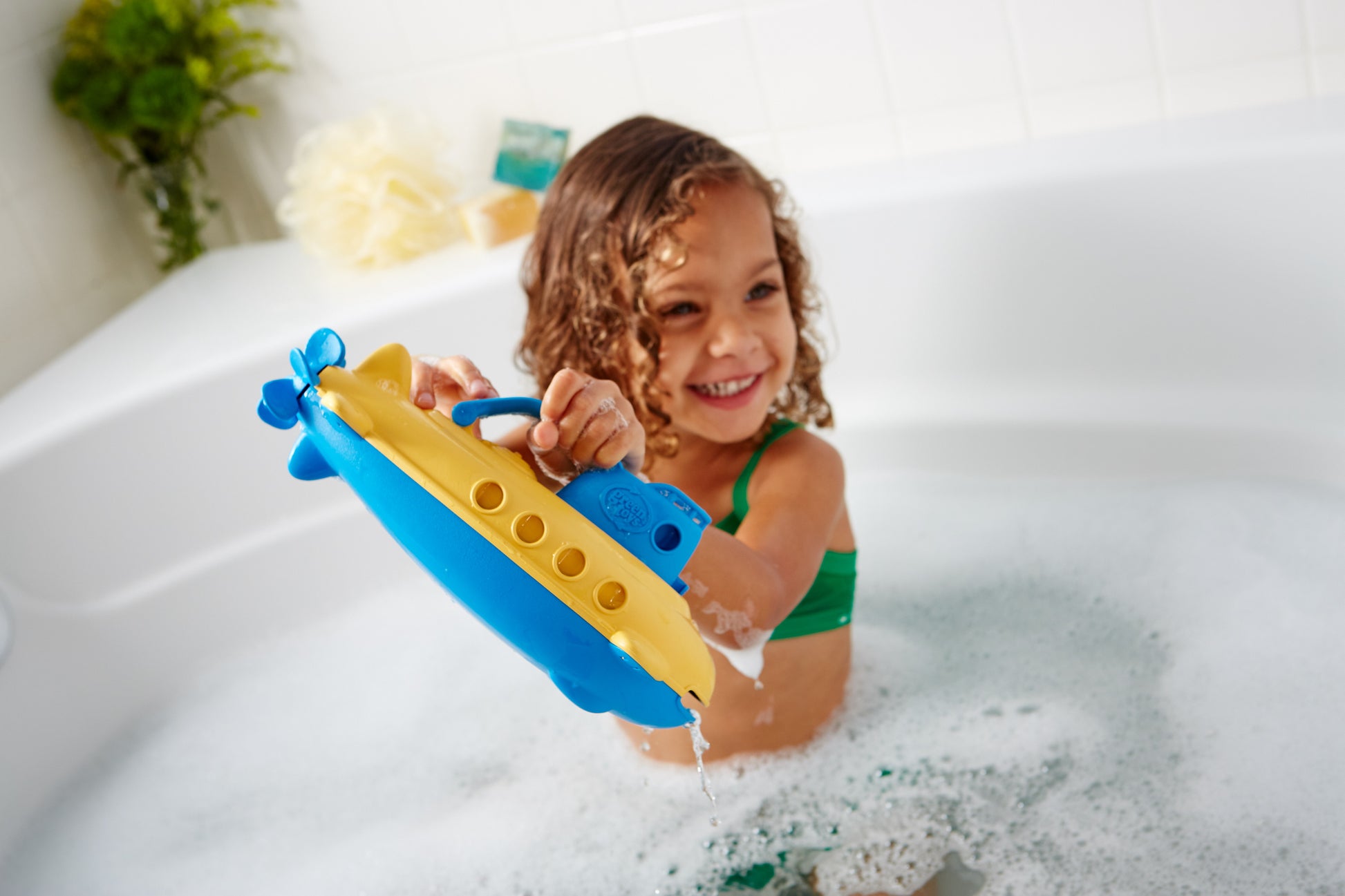 Girl in bath playing with Submarine