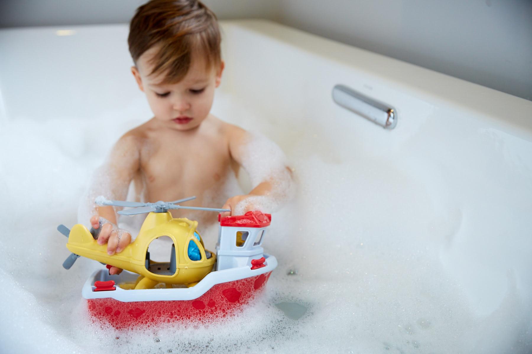 Boy in bath playing with Rescue Boat & Helicopter