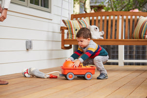Boy playing with Orange Wagon