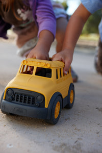 Children's hand holding School Bus