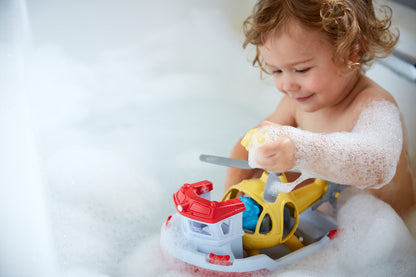 Child in bath playing with Rescue Boat & Helicopter