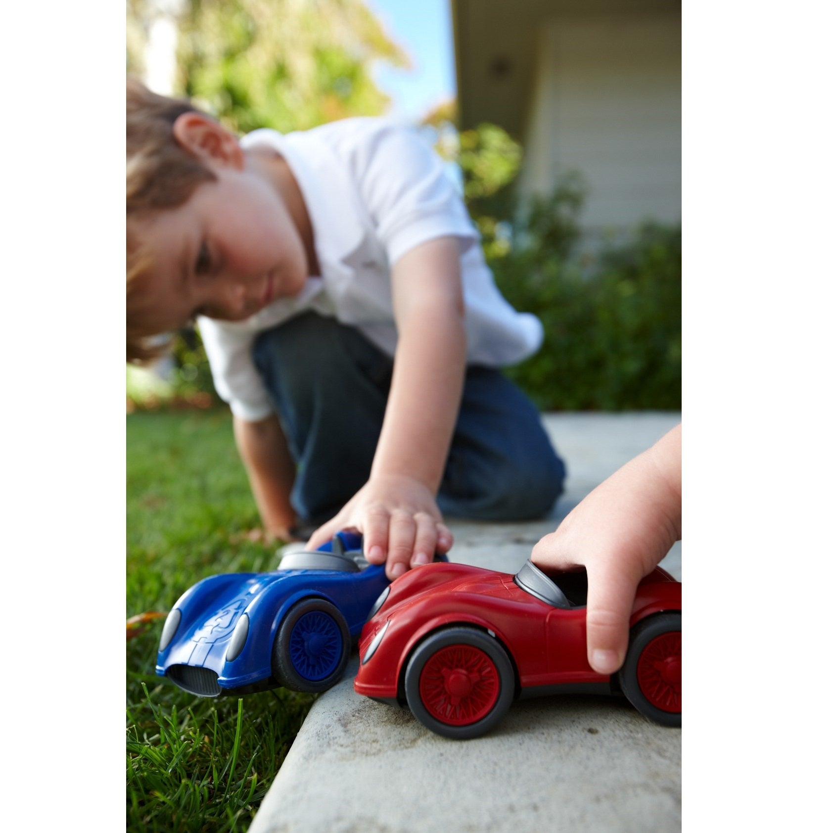 Children playing with Red and Blue Race Cars