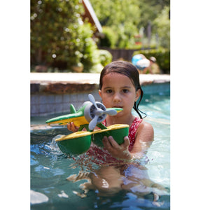 Girl in pool playing with Green Seaplane
