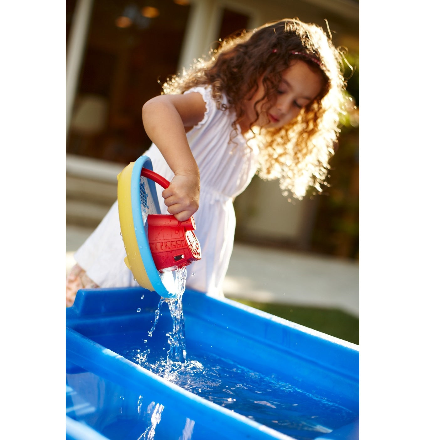 Girl playing with Red Tug Boat in water