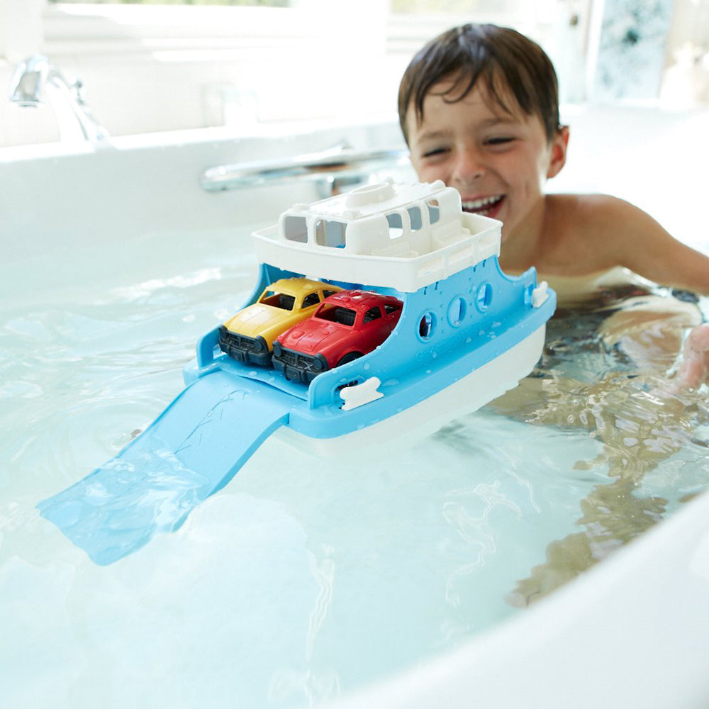 Boy in bath playing with Ferry Boat with yellow and red mini cars